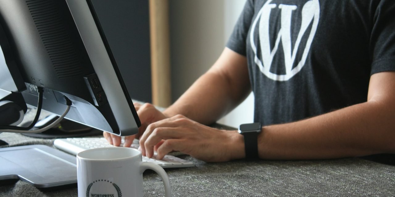 person in black and white t-shirt using computer